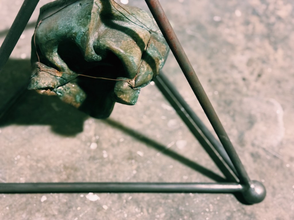 archetypal geometry and minimalistic form in iron enclosing an orgasnic abstraction in bronze at it's centre.